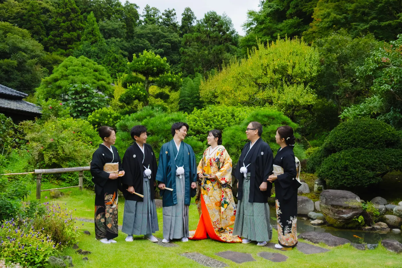 庭園で談笑する和装のおふたりとご家族